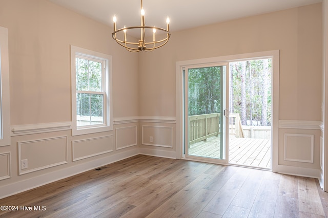 1725 Longleaf Dr E, Pinehurst, NC 28374 - unfurnished dining area featuring an inviting chandelier, visible vents, wainscoting, a decorative wall, and hardwood / wood-style flooring