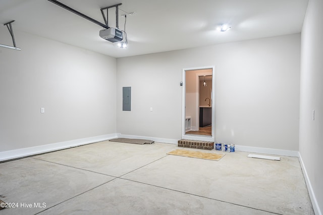 garage featuring electric panel, a garage door opener, and baseboards