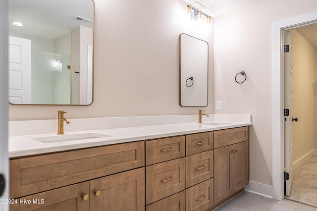 full bath with double vanity, visible vents, baseboards, and a sink