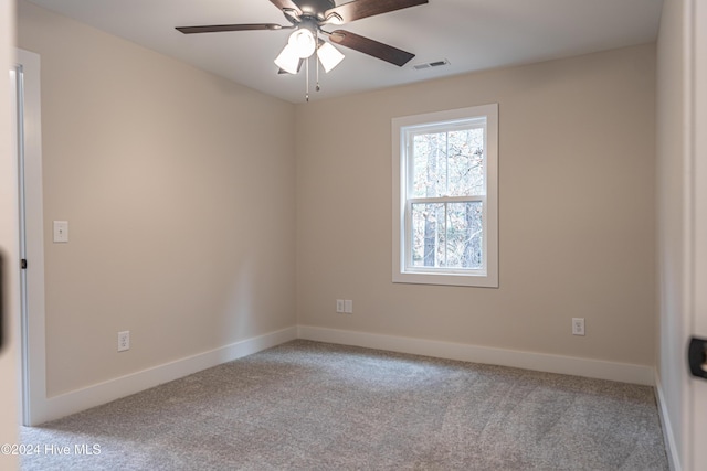 spare room with visible vents, baseboards, carpet, and ceiling fan