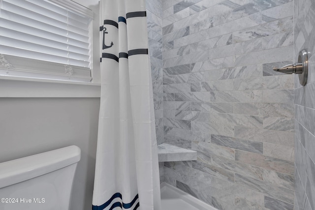 bathroom featuring curtained shower and toilet