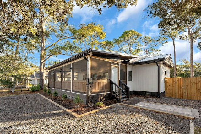 exterior space with solar panels and a sunroom