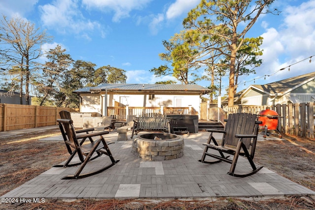 view of patio / terrace with a deck, an outdoor fire pit, and a grill