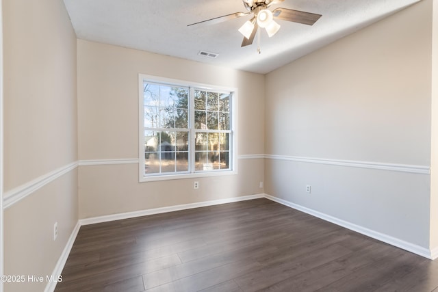 empty room featuring ceiling fan, a textured ceiling, and dark hardwood / wood-style flooring