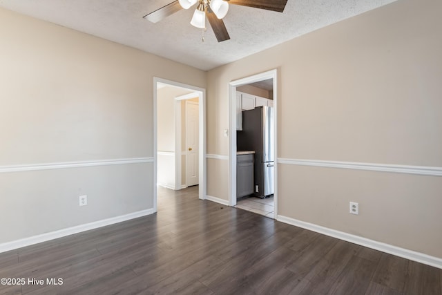 empty room featuring ceiling fan, wood-type flooring, and a textured ceiling