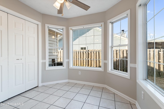 unfurnished sunroom with ceiling fan