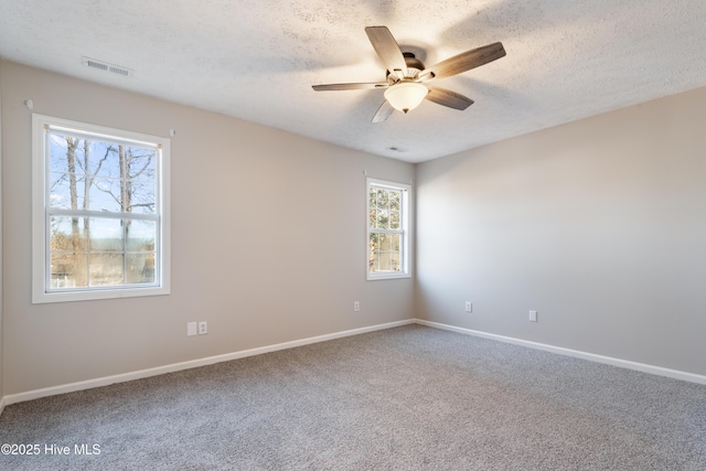 carpeted spare room featuring ceiling fan and a textured ceiling