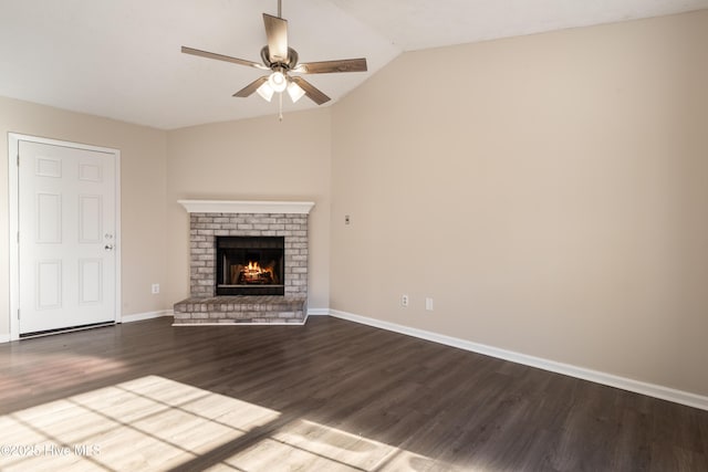 unfurnished living room featuring a brick fireplace, dark wood-type flooring, ceiling fan, and vaulted ceiling