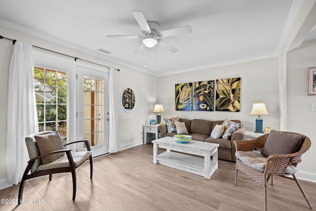 living room featuring light hardwood / wood-style floors, ceiling fan, and crown molding