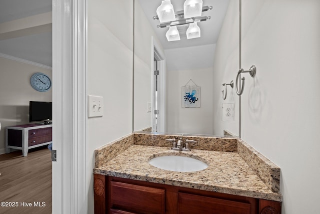 bathroom featuring vanity, wood-type flooring, and crown molding