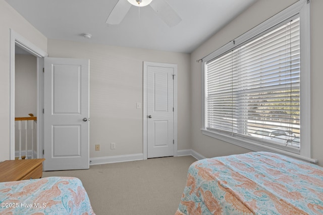 bedroom featuring multiple windows, ceiling fan, and light colored carpet