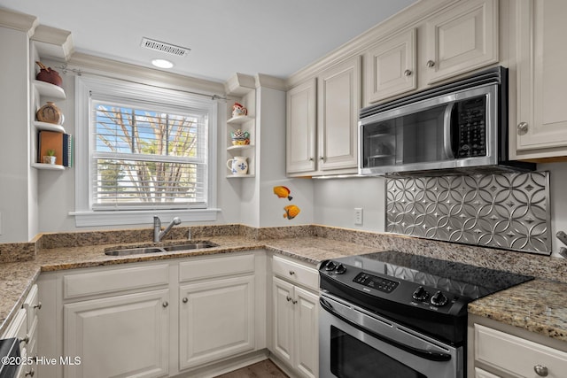 kitchen with white cabinets, stainless steel appliances, light stone countertops, and sink