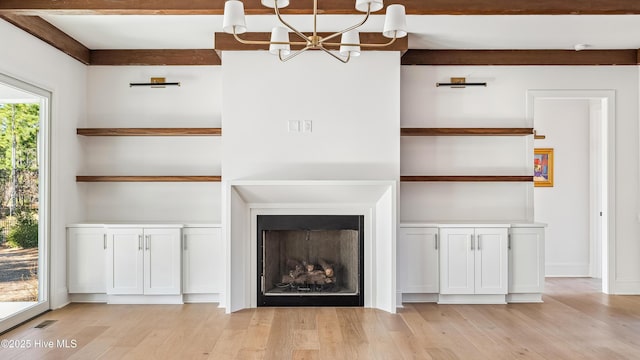 unfurnished living room with light hardwood / wood-style floors and a notable chandelier