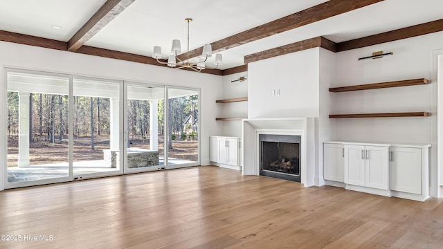 unfurnished living room featuring light wood-type flooring and a chandelier