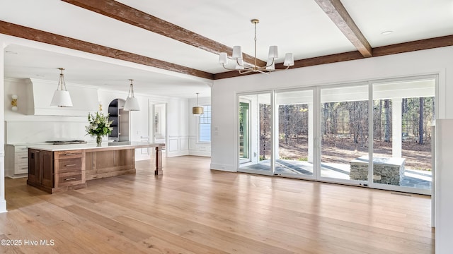 interior space featuring light hardwood / wood-style floors, an inviting chandelier, and beam ceiling