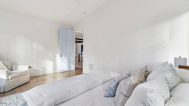 bedroom with hardwood / wood-style floors and lofted ceiling