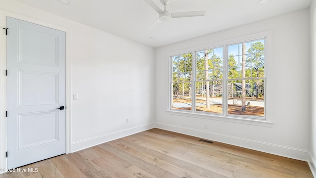 empty room with ceiling fan and light hardwood / wood-style floors