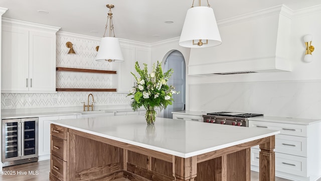 kitchen with white cabinets, beverage cooler, and premium range hood