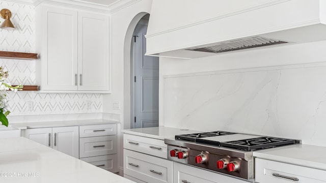 kitchen with white cabinets, premium range hood, and stainless steel gas stovetop