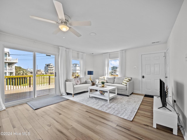 living room with light hardwood / wood-style flooring and ceiling fan