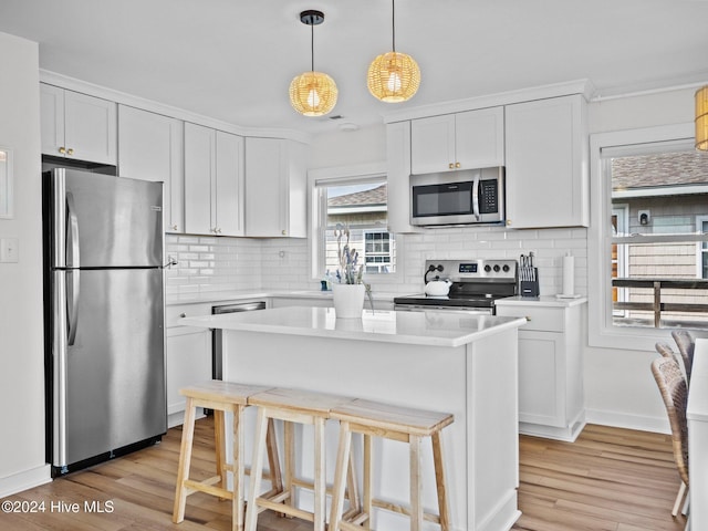 kitchen with white cabinets, stainless steel appliances, and light hardwood / wood-style floors