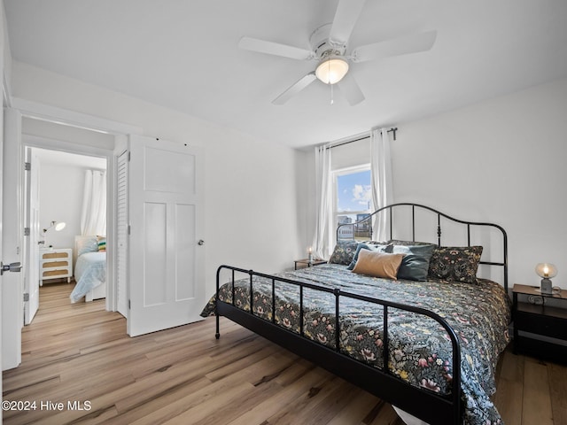 bedroom with light hardwood / wood-style flooring and ceiling fan