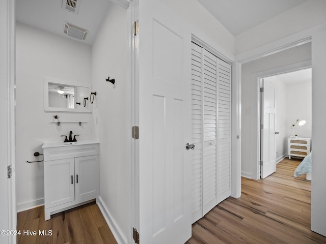 corridor with sink and light hardwood / wood-style floors