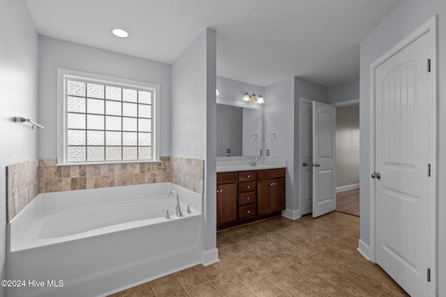 bathroom with tile patterned floors, vanity, and a tub