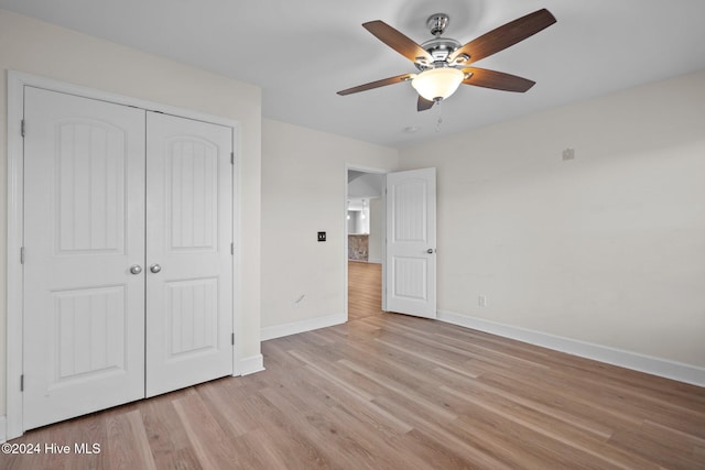 unfurnished bedroom with ceiling fan, a closet, and light hardwood / wood-style flooring