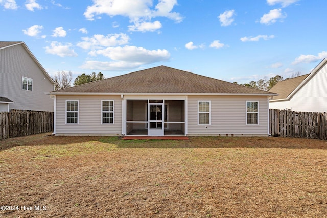 rear view of property with a yard and a sunroom