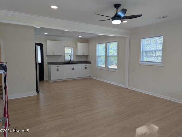 kitchen featuring white cabinets, light hardwood / wood-style floors, crown molding, and sink