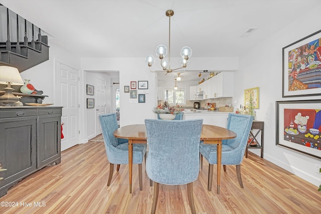 dining space with a chandelier and light hardwood / wood-style floors