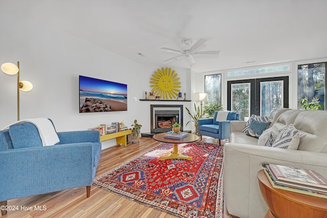 living room with ceiling fan, floor to ceiling windows, wood-type flooring, and french doors