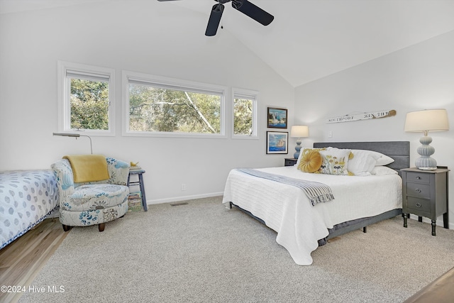 bedroom with ceiling fan, wood-type flooring, high vaulted ceiling, and multiple windows