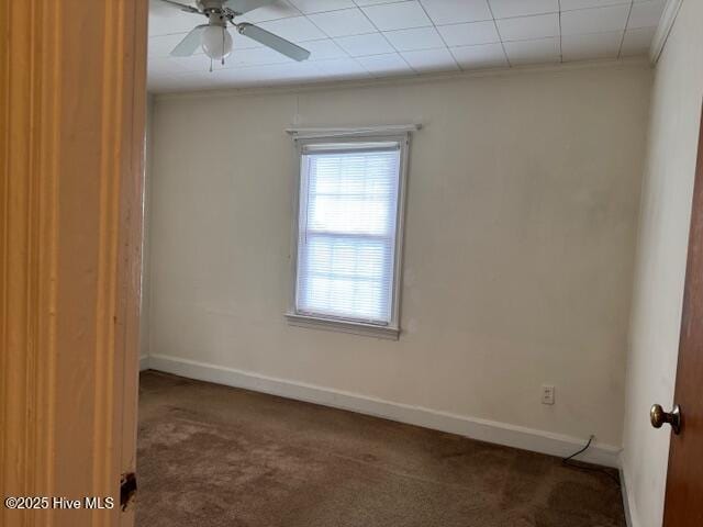 carpeted spare room featuring baseboards, crown molding, and ceiling fan