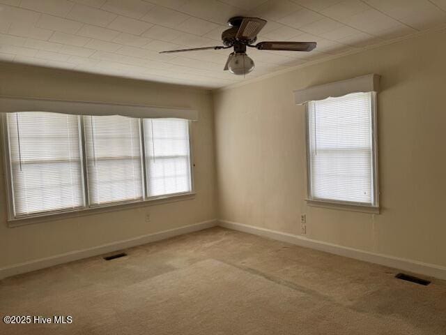 unfurnished room with baseboards, ornamental molding, visible vents, and light carpet