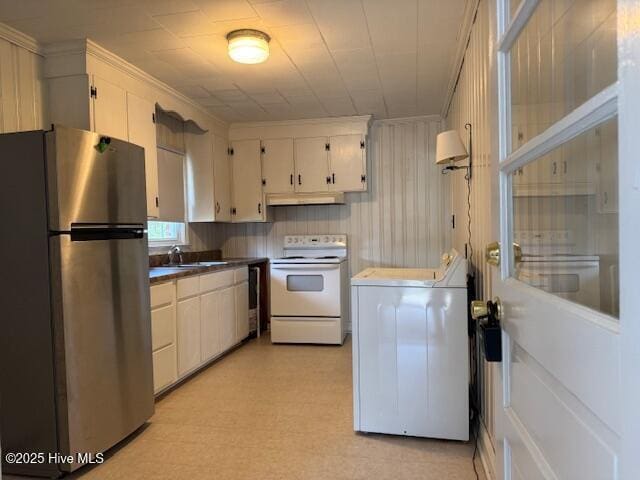 kitchen featuring under cabinet range hood, a sink, white electric stove, washer / dryer, and freestanding refrigerator