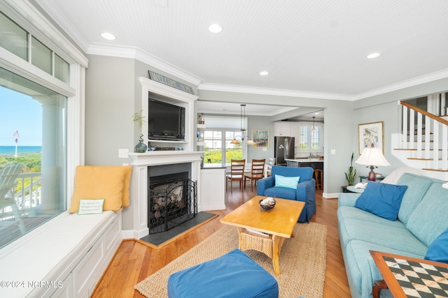 living room with crown molding and light hardwood / wood-style floors