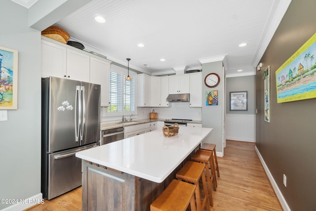 kitchen featuring sink, white cabinetry, appliances with stainless steel finishes, a kitchen island, and pendant lighting