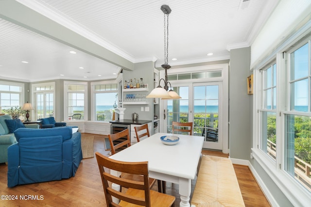 dining room featuring crown molding, plenty of natural light, and light hardwood / wood-style flooring