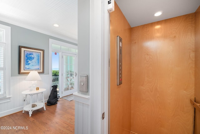 hall with elevator and wood-type flooring