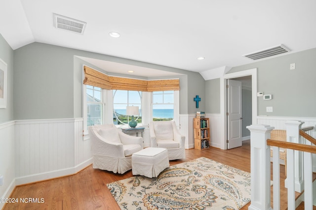 sitting room featuring lofted ceiling and light hardwood / wood-style floors