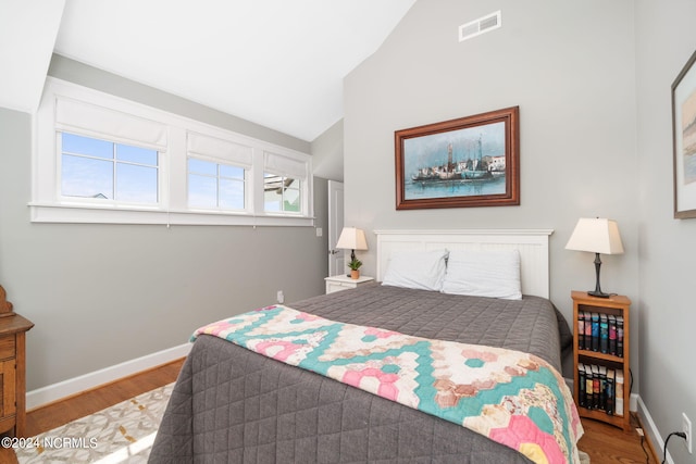 bedroom with lofted ceiling and hardwood / wood-style floors