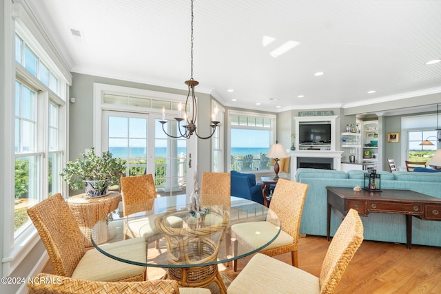 dining space featuring crown molding, an inviting chandelier, and light hardwood / wood-style flooring