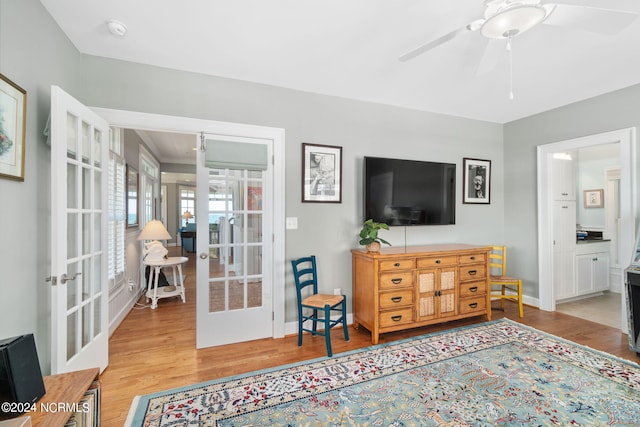 living room with wood-type flooring, ceiling fan, and french doors