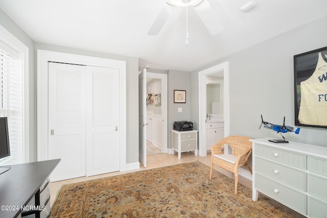 interior space with ensuite bath, ceiling fan, and a closet