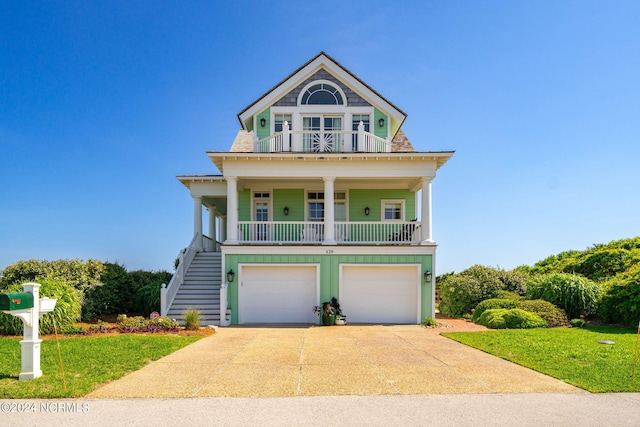 view of front facade with a garage, a balcony, a porch, and a front yard