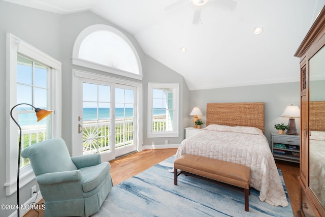 bedroom featuring lofted ceiling, a beach view, a water view, light hardwood / wood-style flooring, and access to outside