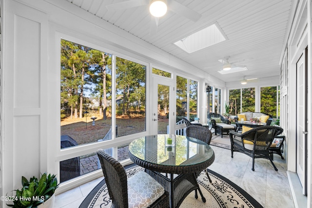 sunroom / solarium featuring ceiling fan, a healthy amount of sunlight, and a skylight