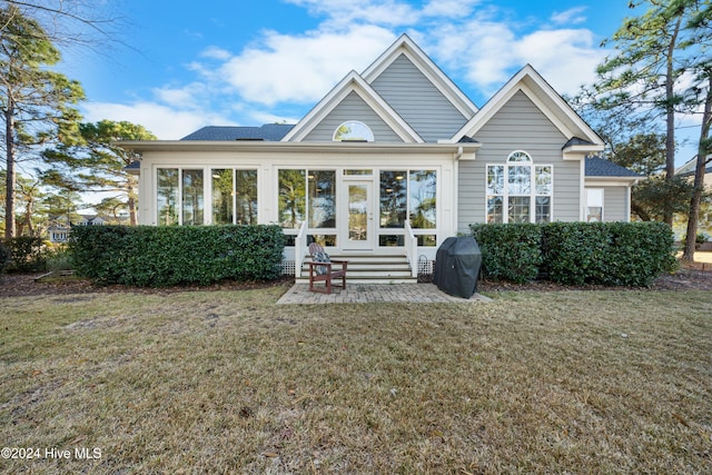 back of house featuring a yard and a sunroom